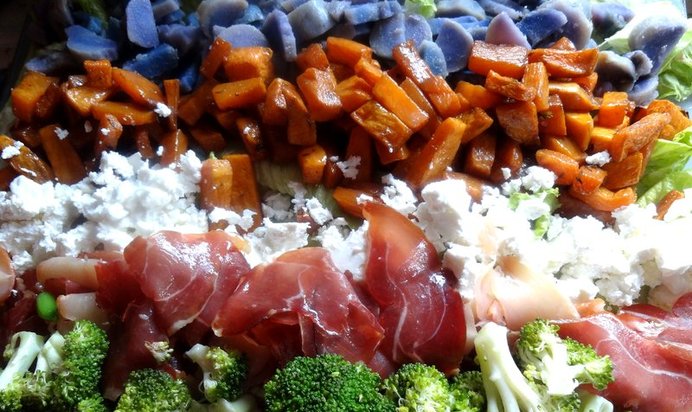 Слоеный овощной салат с прошутто и фетой на доске