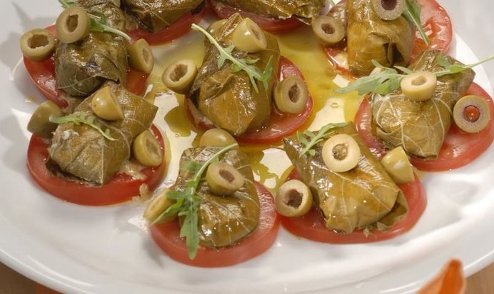 Козий сыр в виноградных листьях с томатами и оливками