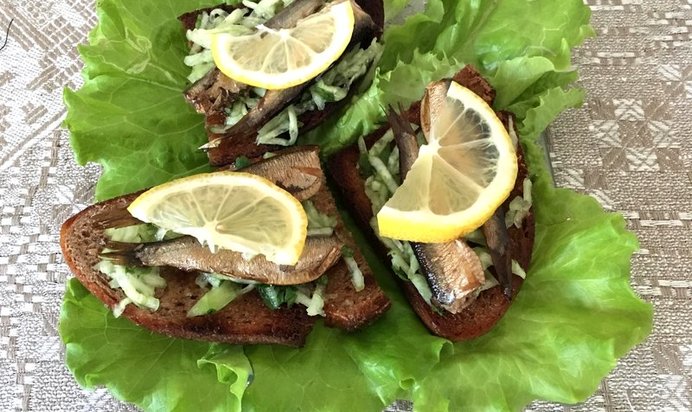 Закусочные бутерброды со шпротами зеленью и лимоном