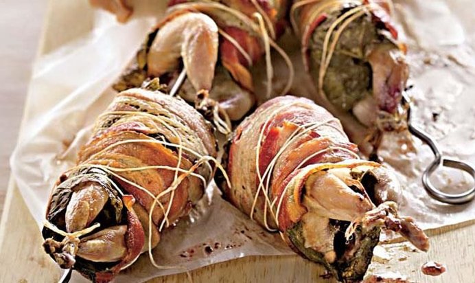 Перепела на вертеле в беконе и виноградных листьях